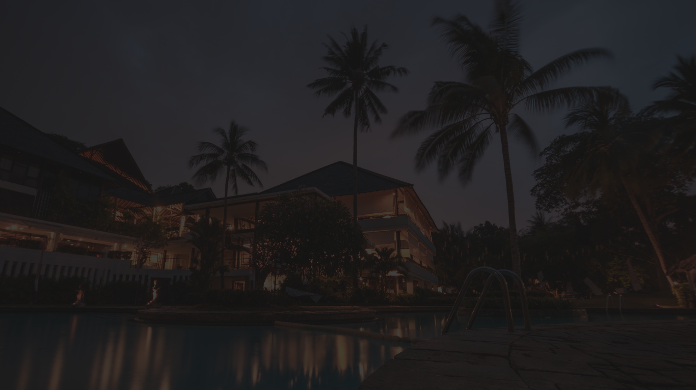 Hotel exterior at night with pool