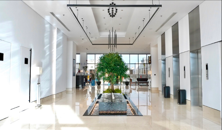 Modern hotel lobby with tree and fountain